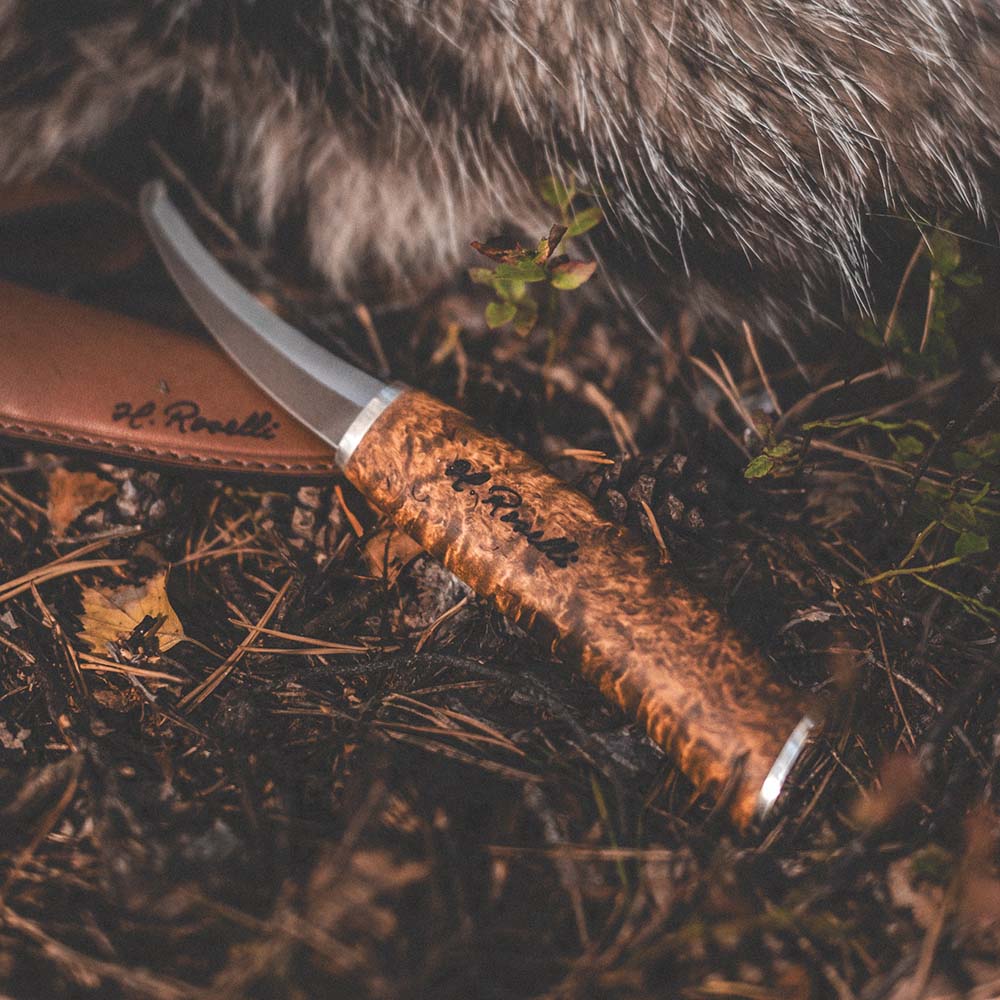 Rosellis handgjorda finska jaktkniv i modellen "buköppnare" med handtag gjort av betsad masurbjörk och exklusiva detaljer av silverbeslag.