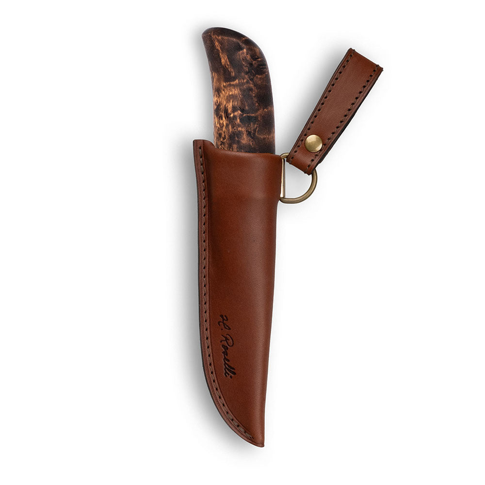 En handgjord finsk kniv i begränsad upplaga, tillverkad av premium kolstål med ett mörkbetsat skaft av masurbjörk. Levereras med en handgjord slida i finskt, vegetabiliskt garvat läder.