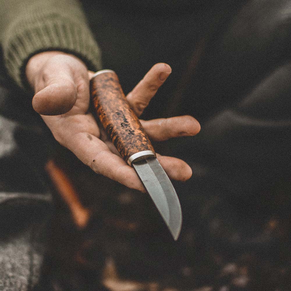 Rosellis finska handgjorda jakt & friluftskniv "Carpenter knife" gjort på UHC stål och ett handtag av masurbjörk smyckat med exklusiva silverbeslag. Levereras med ett handgjort läderfodral av naturgarvat finskt mörkt läder.