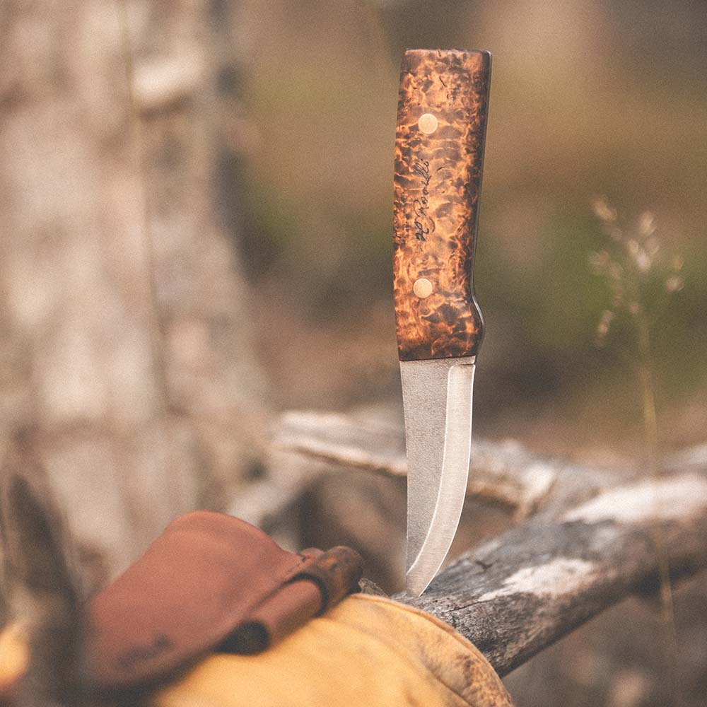Rosellis handgjorda finska jaktkniv med ett fulltånge knivblad gjort av kolstål och ett handtag av betsad masurbjörk. Kommer med ett mörkt naturgarvat kombofodral av läder och Rosellis eldstål.