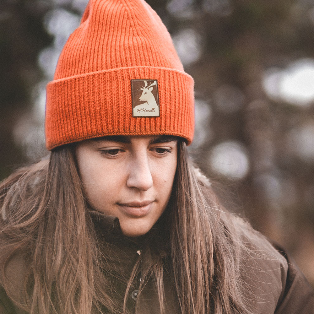 Rosellis orangea jaktmössa med läderpatch. Gjord på kaschmir och merinoull.