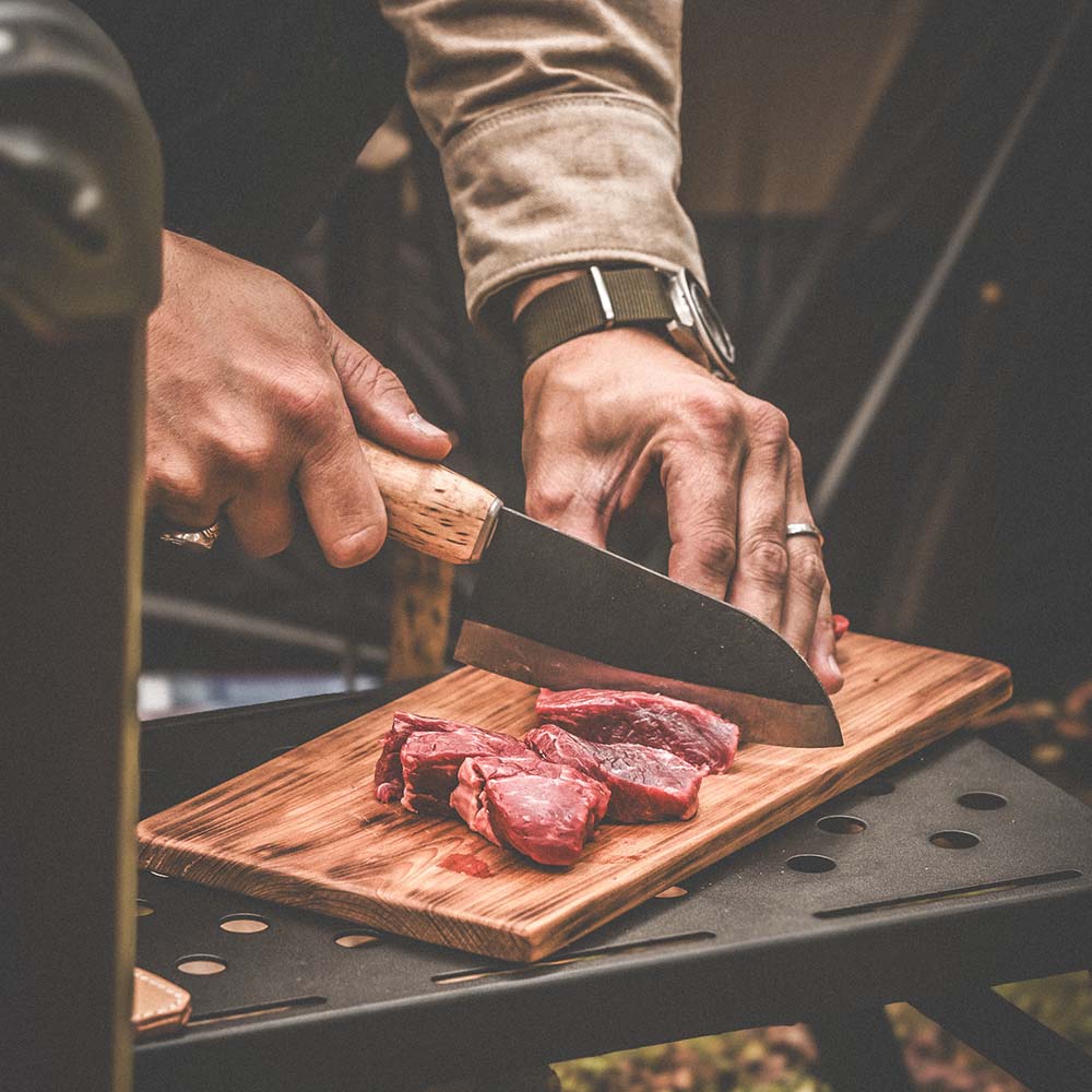 Rosellis finska handgjorda kökskniv av kolstål, perfekt för utomhuslagning och inomhuslagning. Levereras med ett handgjord fodral av finskt naturgarvat läder.